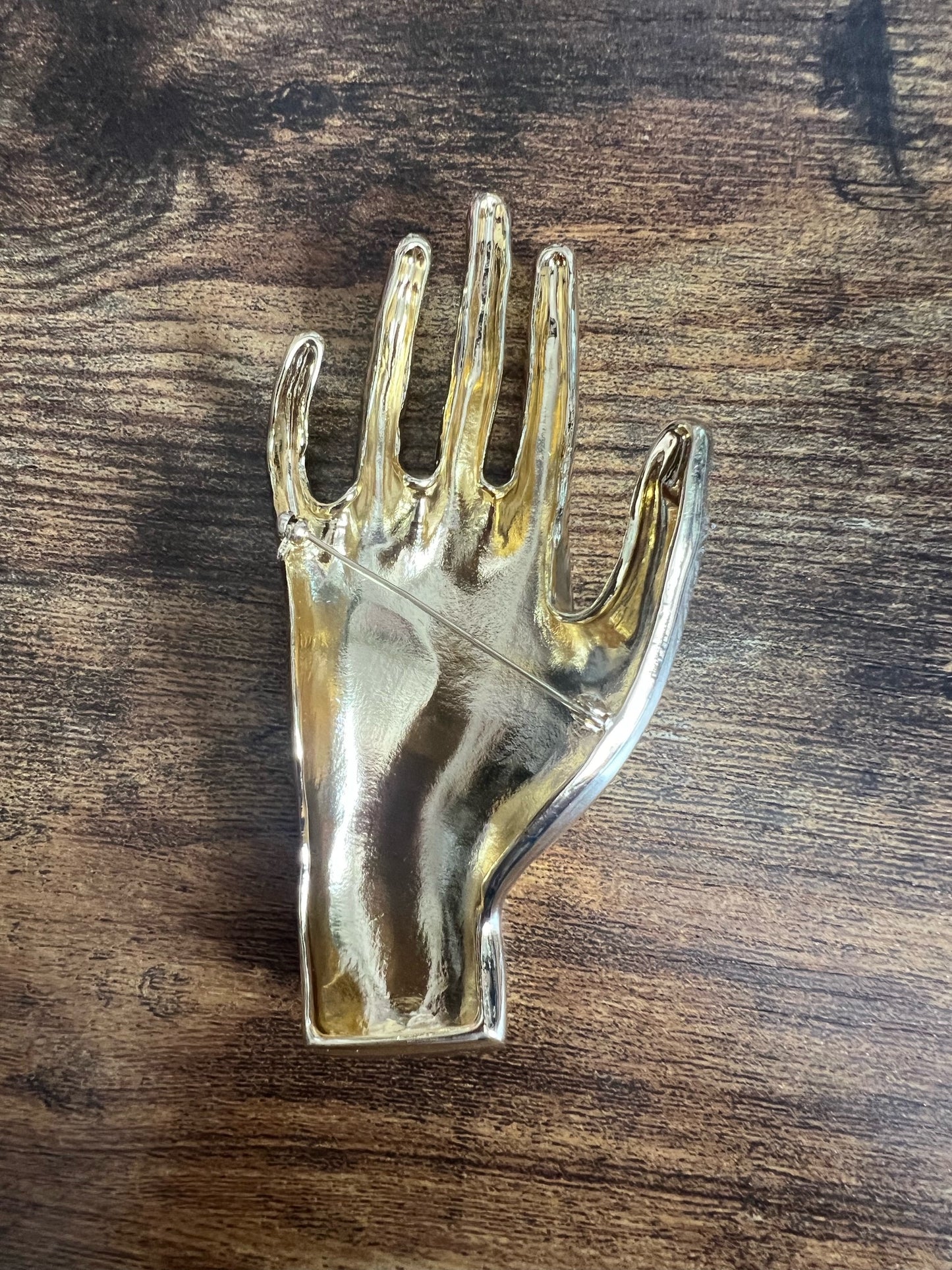 Broche mano dorado